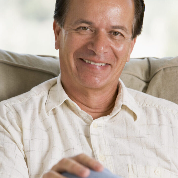 Man sitting in living room smiling Man sitting in living room smiling